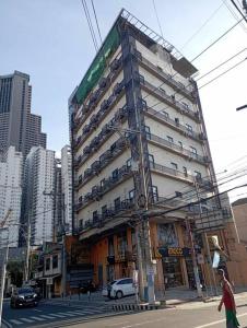 a tall building on a city street with cars at St. Marvin Studio Makati M307 in Manila