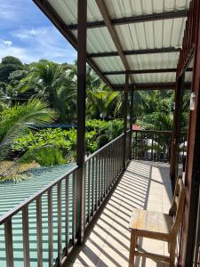 um alpendre com um banco e vista para o oceano em Tortuguero Hill Rooms em Tortuguero