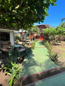 un jardín con mesa y bancos frente a un edificio en Tortuguero Hill Rooms, en Tortuguero