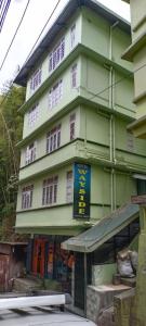 un edificio verde con un cartel delante en HOTEL WAYSIDE, en Gangtok
