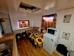 a small bedroom with a bed and a microwave at Rose City Caravan Park in Warwick