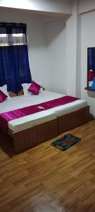 Un dormitorio con una cama con sábanas moradas y una ventana en HOTEL WAYSIDE, en Gangtok