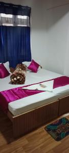 1 cama con almohadas moradas y cortina azul en HOTEL WAYSIDE, en Gangtok