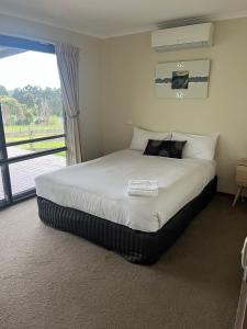 a large bed in a bedroom with a window at Warragul Views Motor Inn in Warragul