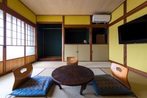 a room with a table and chairs and a tv at 三津ミーツ in Mitsuhama