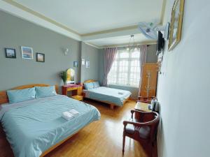 a bedroom with a bed and a chair in it at Anh Hào Hotel in Da Lat