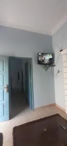 een woonkamer met een tv aan de muur bij VILLA INTAN PALEMBANG in Talangbetutu