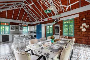 a kitchen and dining room with a table and chairs at StayVista at Vanya Farms - Orchard Villa with Rustic Vintage interiors & Table Tennis table in Alibag