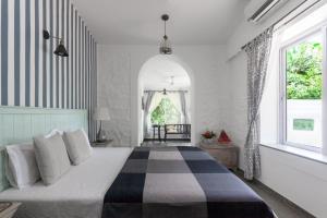 a bedroom with a large bed in a room at StayVista at Vanya Farms - Orchard Villa with Rustic Vintage interiors & Table Tennis table in Alibag +20 photos