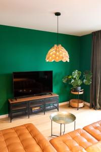 een woonkamer met een bank en een flatscreen-tv bij Leaf Apartment - Aviatiei Home in Boekarest