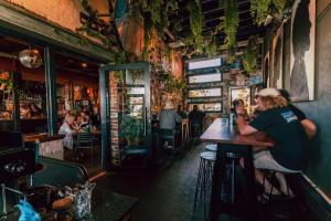 a woman sitting at a table in a restaurant at Six Degrees Boutique Hotel in Albany