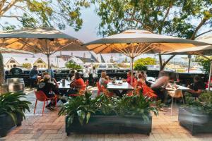 a group of people sitting at tables under umbrellas at Six Degrees Boutique Hotel in Albany