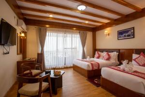 una camera d'albergo con due letti, un tavolo e delle sedie di Hotel Ghyampe Dada a Bhaktapur Altre 17 foto