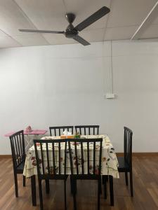un tavolo da pranzo con 2 sedie e un ventilatore a soffitto di ADEELA HOMESTAY @ BANDAR KUANTAN a Kuantan