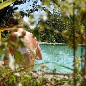 un homme en bikini blanc debout à côté d'une piscine dans l'établissement GlenMyu Estate, à Haputale
