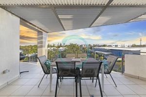 - Balcón con vistas, mesa de comedor y sillas en Zen on Stuart: 3-BR Penthouse Pad + Pool + BBQ, en Stuart Park