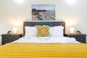 1 dormitorio con 1 cama grande con manta amarilla en Zen on Stuart: 3-BR Penthouse Pad + Pool + BBQ, en Stuart Park