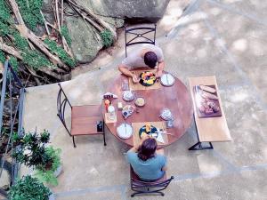 哈普塔拉的住宿－GlenMyu Estate，两人坐在木桌旁,上面有食物