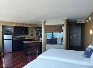 a bedroom with a white bed and a kitchen at Beach Front with Ocean View in Atlantic City