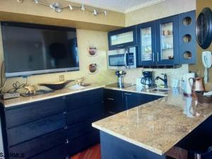 a kitchen with blue cabinets and granite counter tops at Beach Front with Ocean View in Atlantic City