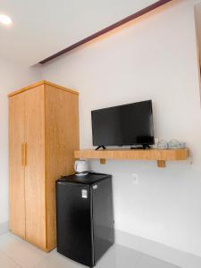 een kamer met een zwarte koelkast en een tv aan de muur bij Love Hotel & Apartments in Vung Tau