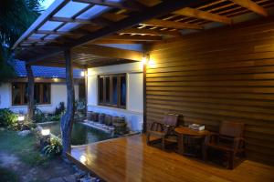 a patio of a house with a table and chairs at Tree Home Plus in Nakhon Si Thammarat