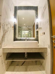 a bathroom with a sink and a large mirror at Evershine Resort & Spa in Mahabaleshwar