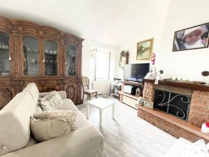 un soggiorno con divano e camino di Appartamento Bellavista a Castelnuovo di Magra