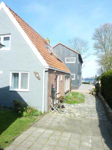 a white house and a house with a pathway at B&B It Lytshûs in Earnewâld