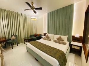 a bedroom with a large bed and a living room at Evershine Resort & Spa in Mahabaleshwar