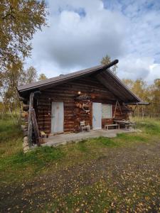 Cabaña de madera con porche y 2 puertas blancas en Villa Lavijoki en Karesuvanto