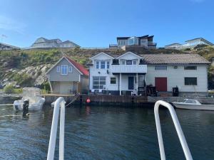 eine Gruppe von Häusern auf einem Dock neben dem Wasser in der Unterkunft Flott rorbu på idylliske Langevåg/Bømlo in Bømlo