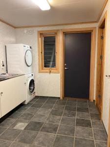 eine Küche mit einer schwarzen Tür und einer Mikrowelle in der Unterkunft Flott rorbu på idylliske Langevåg/Bømlo in Bømlo