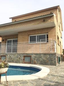 una casa con piscina frente a ella en Casa de Aurora, en Rubí