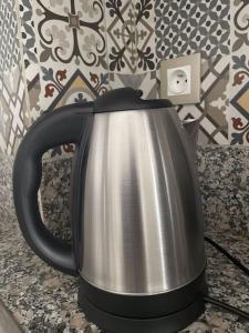 a black and silver tea kettle sitting on a counter at Super studio confortable in Casablanca