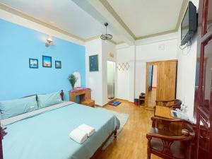 a bedroom with a large bed and a television at Anh Hào Hotel in Da Lat