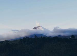 ein Leuchtturm auf einem Berg mit Wolken in der Unterkunft CotopaxGlam in Latacunga