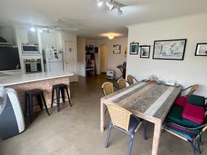 eine Küche und ein Esszimmer mit einem Holztisch und Stühlen in der Unterkunft The Orchid Courthouse - Busselton in Geographe