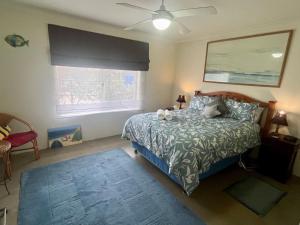 Schlafzimmer mit einem Bett und einem Deckenventilator in der Unterkunft The Orchid Courthouse - Busselton in Geographe