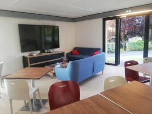 sala de estar con sofá azul y TV en Kyriad Direct Soissons, en Soissons