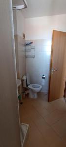 a bathroom with a toilet and a sink and a door at Cozy apartment with sea view in Pomorie