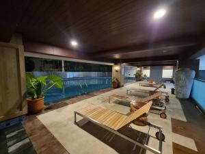 Zimmer mit 3 Bänken und Pool in der Unterkunft The Best Merapi View Apartment By Kinasih Suites in Ngaglik