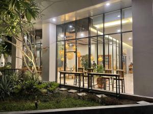 ein Restaurant mit einem Tisch in einem Gebäude mit Fenstern in der Unterkunft The Best Merapi View Apartment By Kinasih Suites in Ngaglik