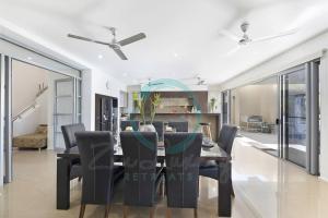 a dining room with a table and chairs at Zen Bayview Bliss: Luxury Marina Mansion in Stuart Park