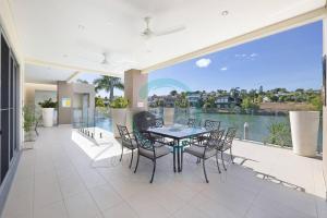 a dining room with a table and chairs and a large window at Zen Bayview Bliss: Luxury Marina Mansion in Stuart Park