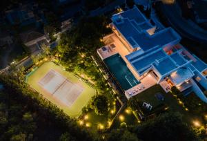 una vista aérea de una pista de tenis por la noche en Buccara Villa El Nido, en Marbella