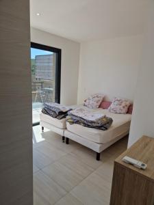 een witte kamer met een bed en een balkon bij Villa Favone 4 chambres piscine privée in Conca