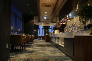a restaurant with a bar with tables and chairs at J One Hotel Cheongju in Cheongju
