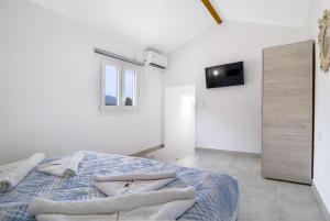 a white bedroom with a bed with pillows on it at Scorpios View Meganisi in Meganisi