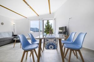 a living room with a table and blue chairs at Scorpios View Meganisi in Meganisi